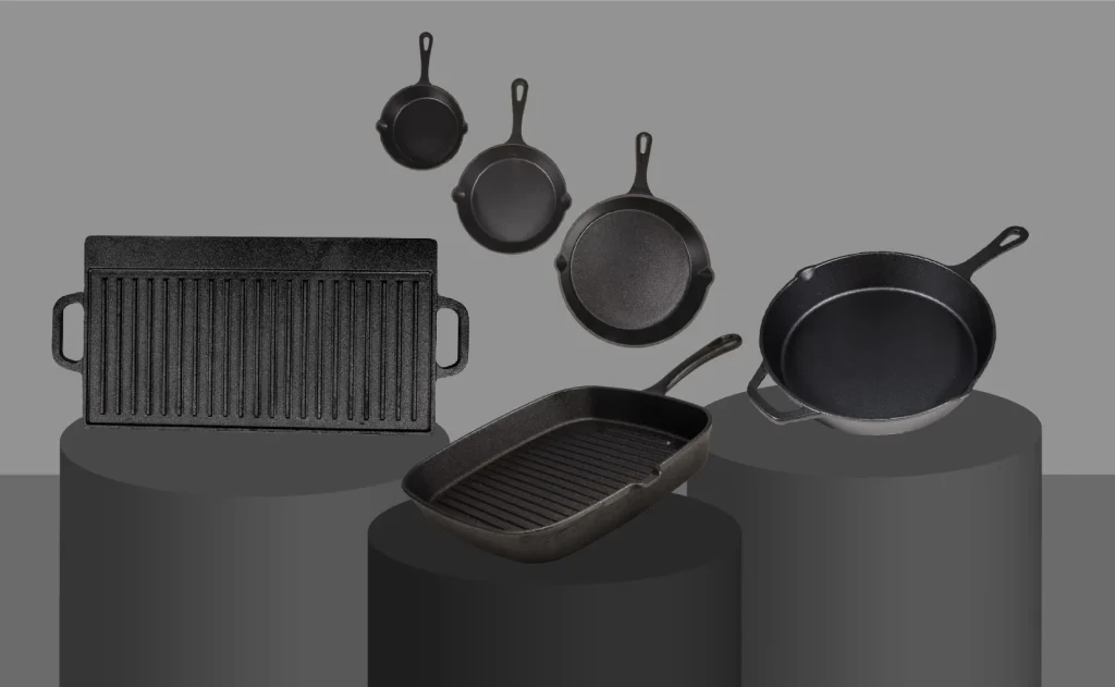 Various cast iron skillets and griddles displayed on marble countertop background