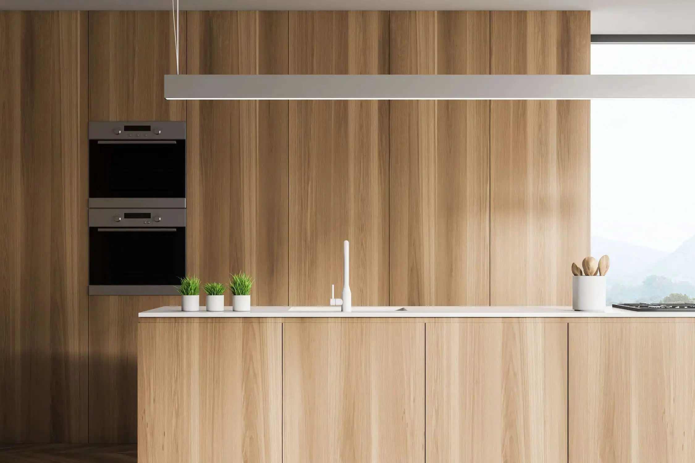 Een minimalistische keuken met naadloze houten kasten, moderne inbouwapparatuur, witte werkbladen en strakke hangende lampen