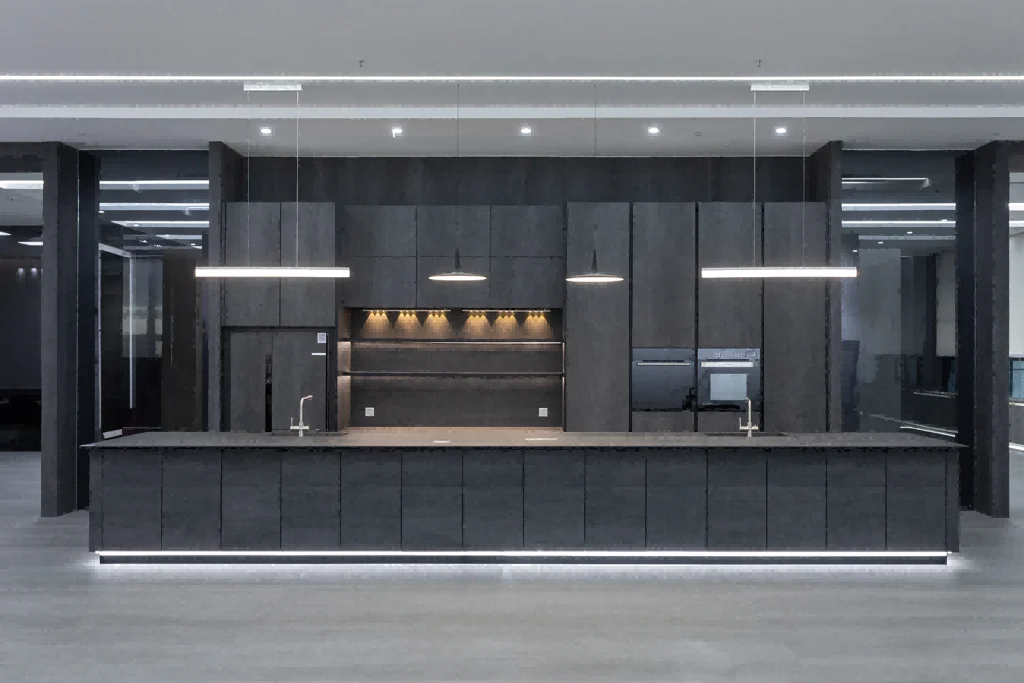 Eine große monochromatische Küche mit dunklen Schränken, einer großen Insel und markanter linearer Beleuchtung darüber