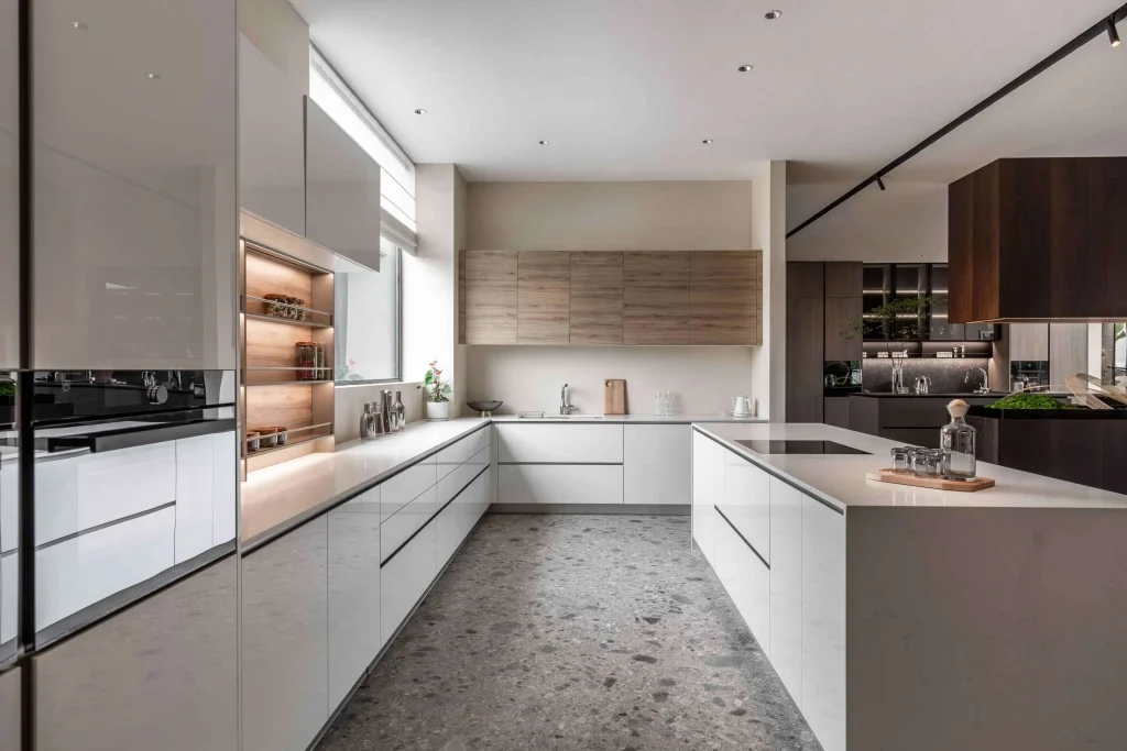 Helle Küche mit weißen und hellen Holzschränken, einer zentralen Insel mit Spüle und weißen Arbeitsplatten