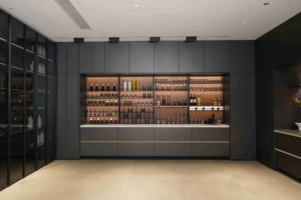 ダークウッドとホワイトの要素をあしらったツートンカラーのキャビネット、中央のアイランド、装飾的な植物を備えた豪華なキッチン ダークウッドとホワイトの要素をあしらったツートンカラーのキャビネット、中央のアイランド、装飾的な植物を備えた豪華なキッチン