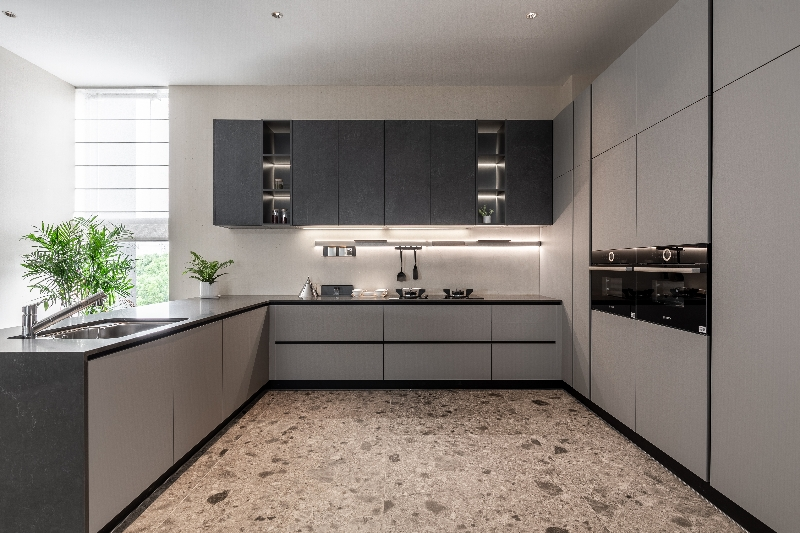 Moderne Küche mit minimalistischen grauen Schränken, integrierten Geräten und LED-Beleuchtung unter den Regalen