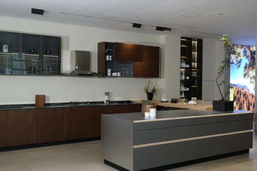 Geräumige Küche mit dunklen Holzschränken, einer großen Insel mit Kochfeld und natürlichem Licht, das die warmen Töne ergänzt